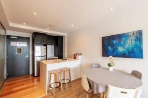 オークランドにあるSkytower and City View 2 Bedroom Apartment on High Floorのテーブルと椅子のあるキッチンとダイニングルーム