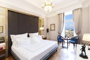 a bedroom with a large bed and a chandelier at Grand Hotel Parker's in Naples