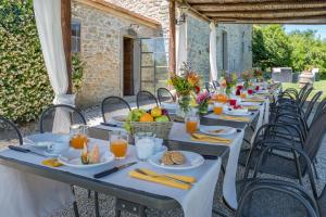 długi stół z talerzami żywności w obiekcie NONNO FERNANDO 18&4, Emma Villas w mieście Cortona
