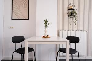 a white table with two chairs and a vase on it at Urban Elegance - Stylish Central Accommodation in Bucharest +25 photos