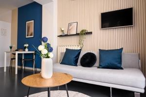 a living room with a couch with blue pillows at Urban Elegance - Stylish Central Accommodation in Bucharest
