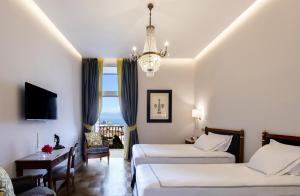 a hotel room with two beds and a chandelier at Grand Hotel Parker's in Naples