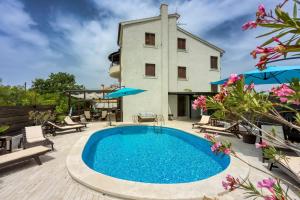 a villa with a swimming pool in front of a building at Villa Betiga in Mednjan