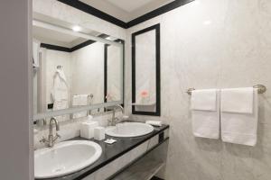 a bathroom with two sinks and a mirror and towels at Grand Hotel Parker's in Naples