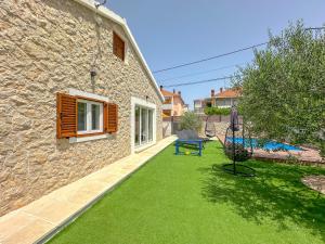 a stone house with a yard with a bench at MUSTRA House Zadar - Private Pool & Sauna in Zadar