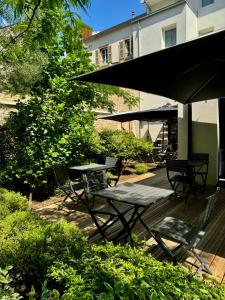 a patio with a table and chairs under an umbrella at Hôtel des Halles in Dijon