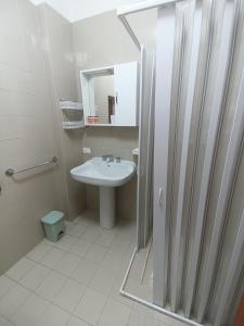 um banheiro branco com uma pia e um espelho em Sunset Villa em Torre Lapillo