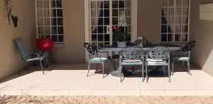 a dining room table and chairs in a house at Green Willows Guest House in Skeerpoort