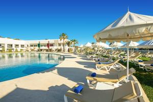 a swimming pool with lounge chairs and a resort at Iberostar Selection Diar El Andalous in Port El Kantaoui