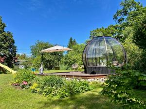 a glass dome sitting on a wooden deck with an umbrella at Private Villa with sauna, hot tub, playground and outside lounge area in Pärnu