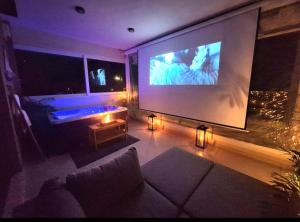 a living room with a large screen with a tv at Seaview apartment with jacuzzi and home cinema in Nea Makri