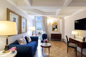 a living room with a blue couch and a desk at Grand Hotel Parker's in Naples