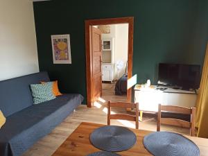 a living room with a blue couch and a television at Apartament przy Wandy in Zielona Góra