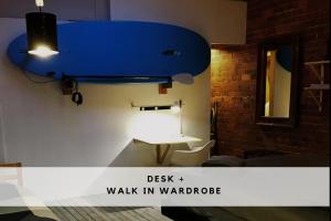 a room with a desk and a blue overhead light at beachside loft warehouse artists retreat in Edithvale +24 photos