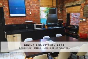 Edithvaleにあるbeachside loft warehouse artists retreatのテーブルと椅子のあるダイニングとキッチンエリア