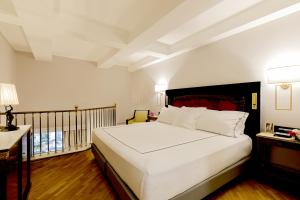 a bedroom with a large white bed and a desk at Grand Hotel Parker's in Naples