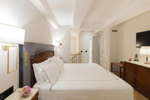 a bedroom with a large white bed and a television at Grand Hotel Parker's in Naples
