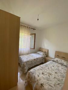 a bedroom with two beds and a window at Villa Pams in Baks-Rrjoll