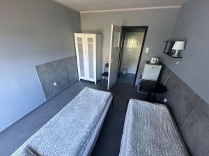 a room with two beds and a chair in it at KEJA Pustkowo in Pustkowo +2 photos