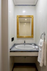 a bathroom with a sink and a mirror at Grand Hotel Parker's in Naples