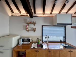 a kitchen with a counter with a microwave and a refrigerator at Hanok Dasi Bom 102 in Gyeongju