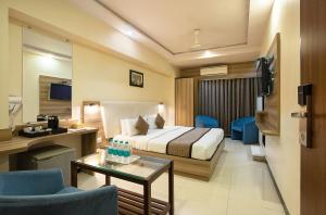 a hotel room with a bed and a table at Hotel Avon Ruby Dadar in Mumbai