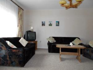 a living room with two black couches and a coffee table at Ferienwohnung in Usedom Town