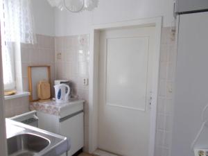 a small white kitchen with a sink and a washing machine at Ferienwohnung in Usedom Town