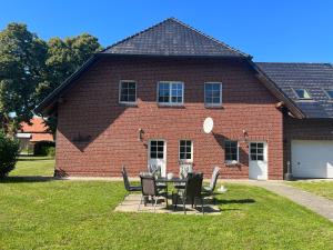 KrienkeFerienwohnung Krienke的砖屋前的桌椅