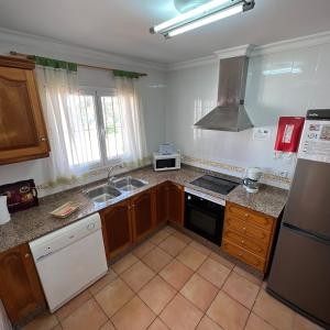 a kitchen with a sink and a stove top oven at Villas Monte Jávea - BTB in Jávea