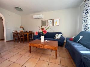 a living room with a blue couch and a table at Villas Monte Jávea - BTB in Jávea