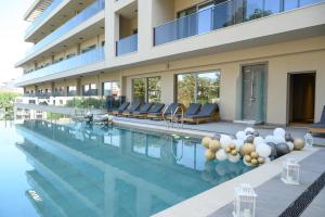 a swimming pool with chairs and a building at Poseidon Beach Resort - Premium All Inclusive & Free Riviera Beach Access in Golden Sands