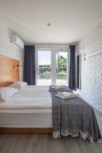 a bedroom with a large bed and a window at Smiltynės Jachtklubas in Klaipėda