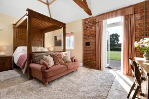 a bedroom with a bed and a couch at The Chestnuts Country House Boutique B&B in Kilvington