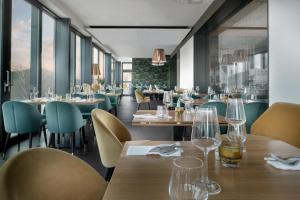 a restaurant with wooden tables and chairs and windows at Hotel Golf Prague in Prague