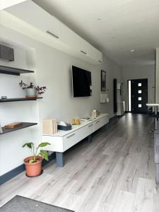 セント・オールバンズにあるLuxury modern apartment with free private parkingの白い壁とウッドフロアの広いリビングルーム