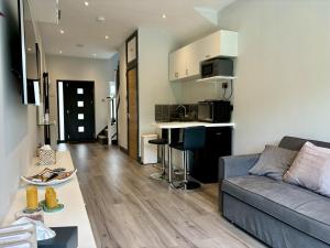 a living room with a couch and a kitchen at Luxury modern apartment with free private parking in St. Albans