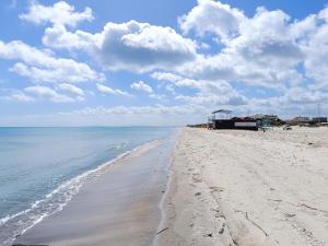 ein Sandstrand mit dem Meer und Wolken am Himmel in der Unterkunft Sawsen Ghar el melh in Ghār al Milḩ