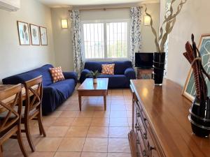 a living room with a blue couch and a table at Villas Monte Jávea - BTB in Jávea