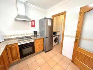 a kitchen with a refrigerator and a stove at Villas Monte Jávea - BTB in Jávea