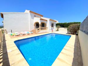 a villa with a swimming pool in front of a house at Villas Monte Jávea - BTB in Jávea
