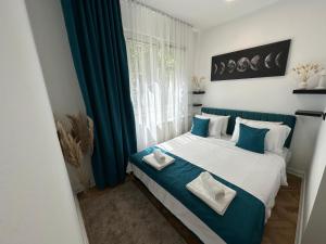 a bedroom with a bed with blue and white pillows at Banovo Brdo Premium in Čukarica