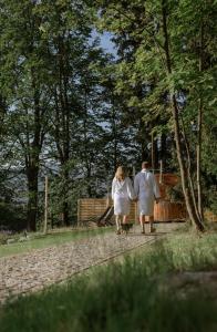 斯克拉斯卡波伦巴Zielony Jeleń - sauna i jacuzzi的走在路上的男人和女人 更多105张照片