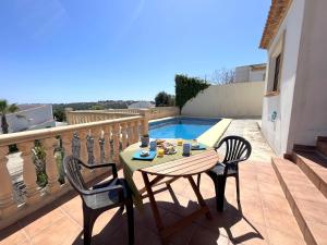 a table and chairs on a balcony with a pool at Villas Monte Jávea - BTB in Jávea