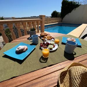 a table with food and drinks on a table near a pool at Villas Monte Jávea - BTB in Jávea