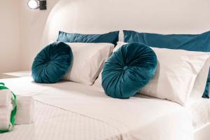 a bed with two green pillows on top of it at Castel Manfredi Apartments in Manfredonia