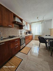 a kitchen with wooden cabinets and a table and a dining room at RIVA GARDEN relax in Novigrad Istria