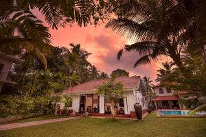 a house with a palm tree in the yard at Fortress de Jayaweera - Historic Villa Bentota - A proud legacy since 1889 in Bentota