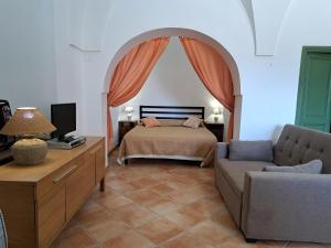 un dormitorio con una cama y un sofá en Marosi, en Pantelleria