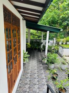 a walkway leading to a house with a wooden door at La Isla Homestay in Kandy +9 photos
